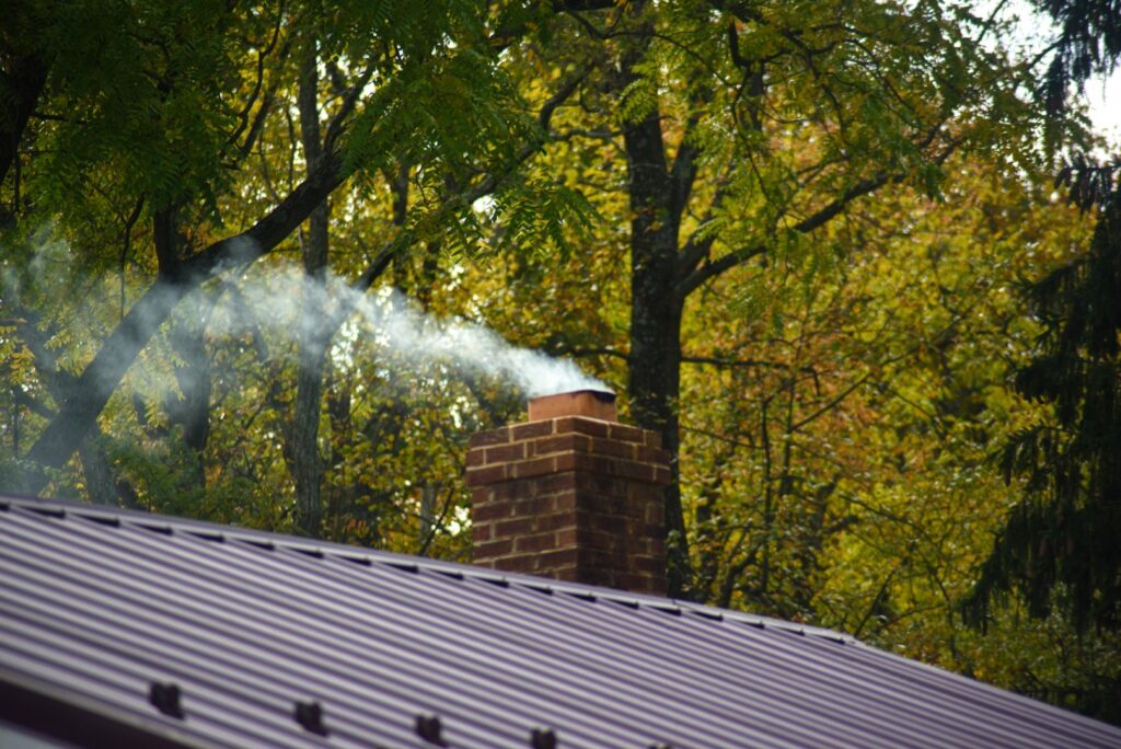 Smoke rising from a clean, well-maintained chimney after an expert repair.